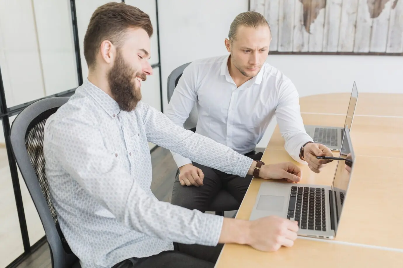 Geschäftsleute arbeiten im Büro an einem Laptop.